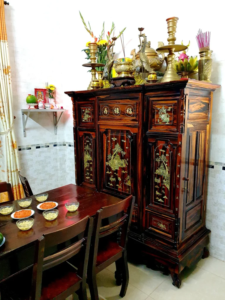 Tủ thờ gỗ khảm xà cừ bày đồ đồng, hoa và nhang đón giao thừa