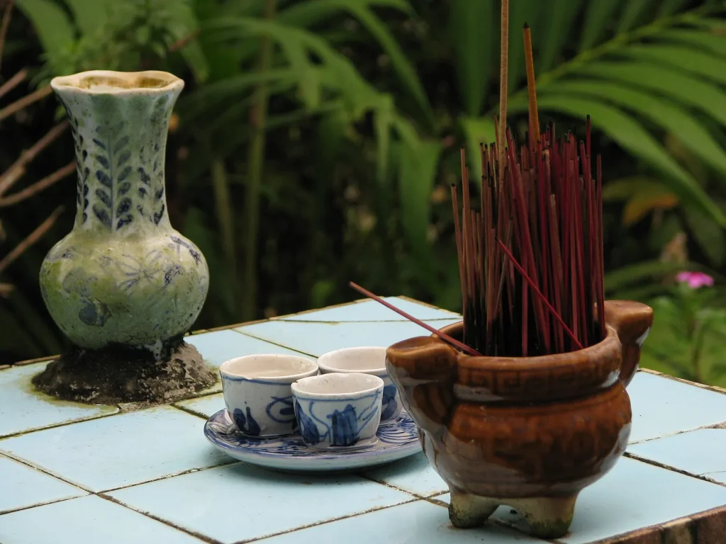 Lư nhang và bộ chén trà men lam trên bàn ngoài hiên nhà